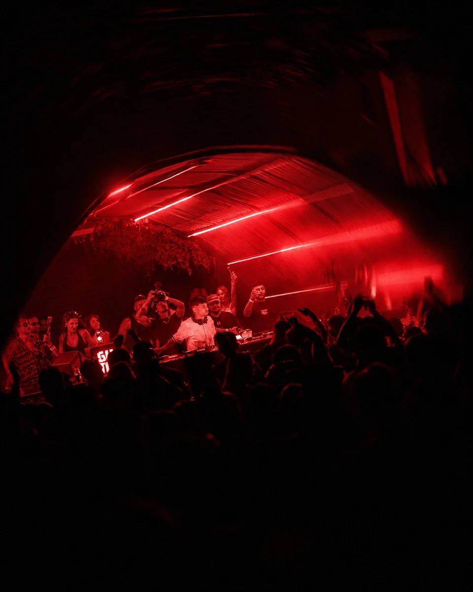 A crowd under red club lights